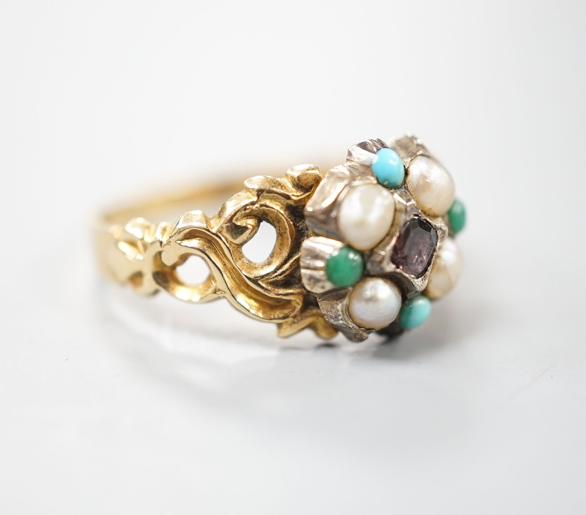 A late Victorian yellow metal, garnet, turquoise and split pearl cluster set dress ring, size M, gross weight 2.9 grams.